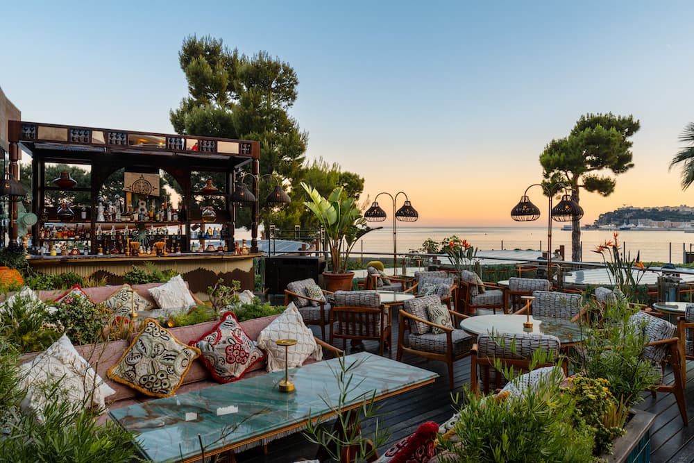 Coya Monte-Carlo's terrace at dusk, the Rocher behind
