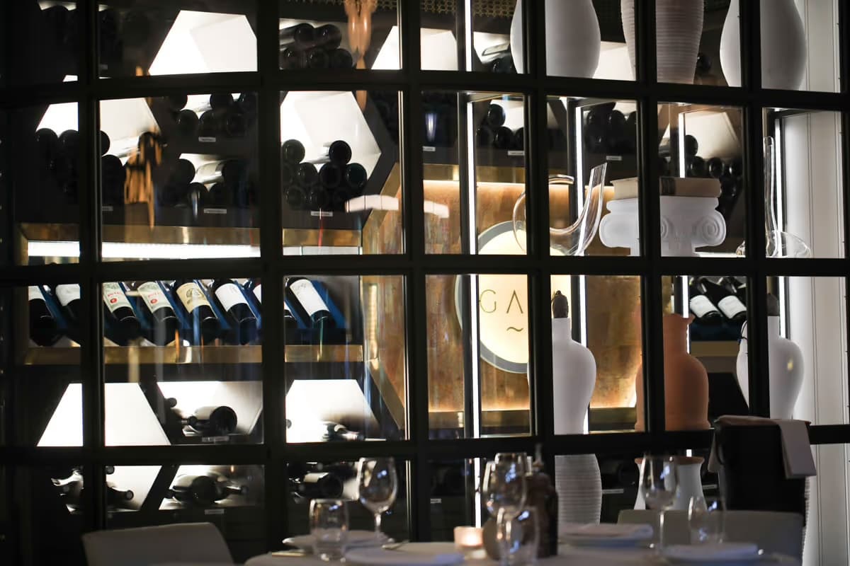 The table before Gaia's illuminated wine-cellar wall