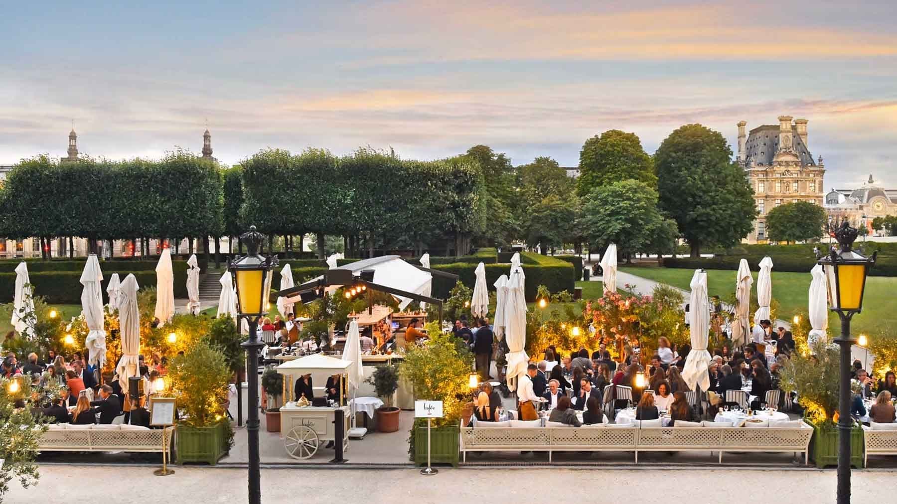 Loulou's Tuileries-side terrace at dusk, the Louvre behind